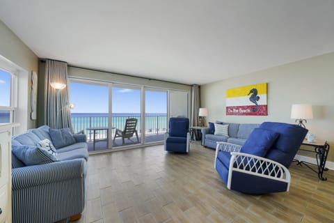 This spacious beachfront living area offers panoramic views of the Emerald Coast through large sliding glass doors, creating the perfect place to relax after a day on the beach.