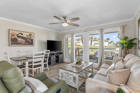 Sink into plush seating and relax in your coastal retreat with palm-lined views through French doors. Fresh tropical breezes and natural light invite you to unwind.