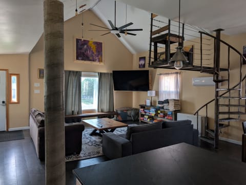 Soaring vaulted living room — spiral staircase, smart TV & room to relax