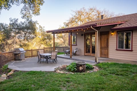Gather for dinner on the patio with string lights and grill