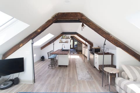 Charming Loft Kitchen: Enjoy culinary adventures in a sunlit space with rustic beams and modern flair!