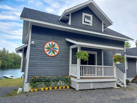 Front of house in summer, abundant flowers with plenty of parking out front.