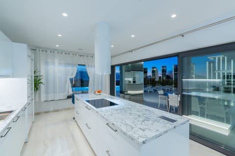 Large kitchen island in a modern kitchen with white color in the interior