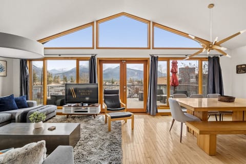 Living room on the second floor with a Smart TV, cozy seating options, walkout access to the backyard and glorious mountain views.