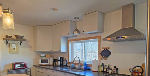 Fully equipped modern kitchen with cookware, utensils, spices, and oils for easy meal preparation.