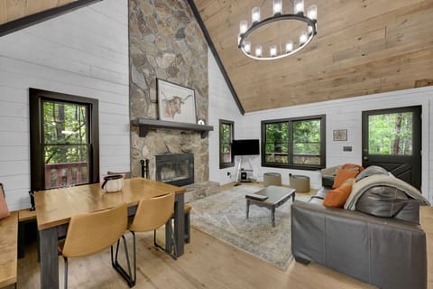 Comfortable main living room with dining, Roku TV, fireplace, and leafy views.