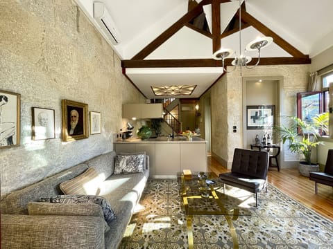 Double height living area with its old wooden structure and opening shutters 