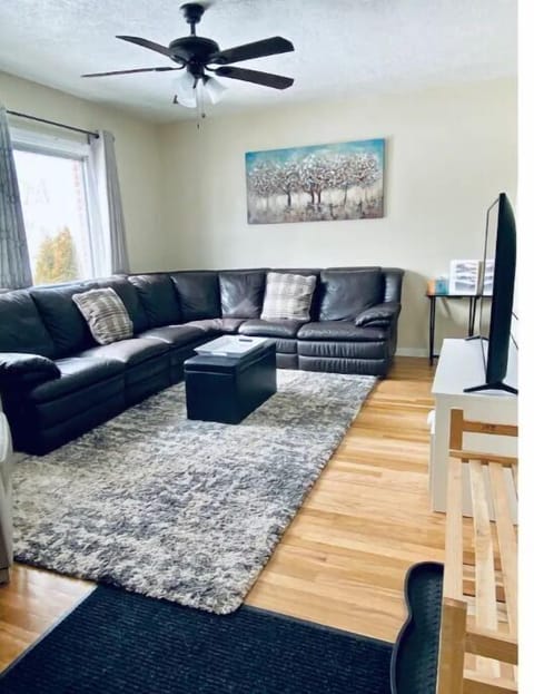 hardwood floors, leather sofa and chair, Big Windows, 55" TV with premium cable.