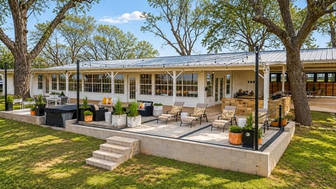 Raised patio, string lights, covered hot tub, and outdoor seating under ancient oaks. The outdoor living at this Granbury vacation rental was designed for evenings that do not end early.