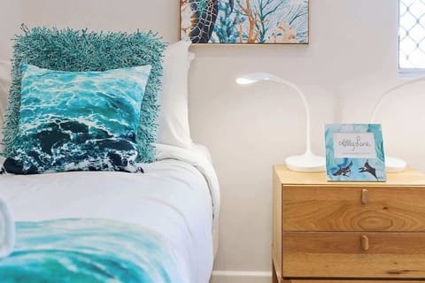Relax in comfort! This inviting bedroom features plush pillows, a captivating painting, a cozy bed, convenient lampshades, a handy bedside cabinet, and natural light from the bedroom window.
