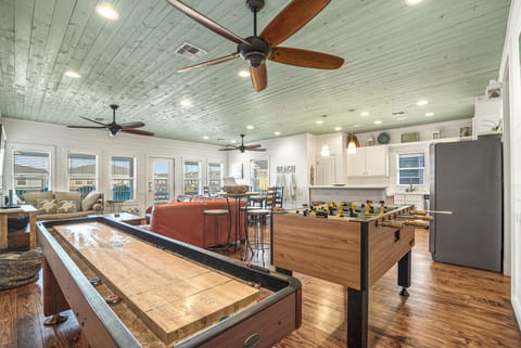 Open concept living, kitchen, dining with foosball and shuffle board.