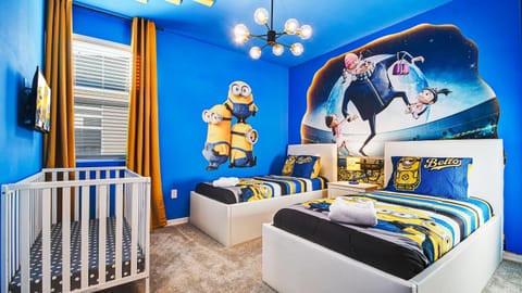 Playful themed kids' room with twin beds, vibrant decor, and a crib.