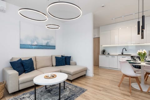 An open-plan living and dining area with a modern aesthetic, featuring a round table and cozy seating.
