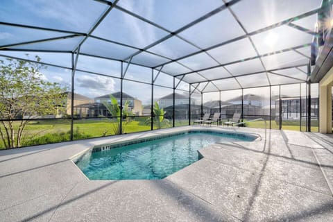 Surrounded by  the warm breeze, the pool area exudes a sense of tranquility. A few lounge chairs beckon, strategically positioned around the poolside, inviting sun-seekers to bask in the glorious weather. 
