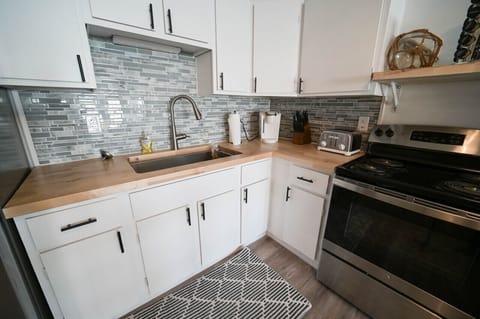 A dream kitchen with stainless steel appliances, and white cabinets, perfect for cooking and entertaining guests.