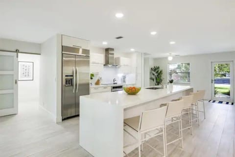 Indulge in our modern chef's kitchen, complete with a spacious island seating 5. Stainless steel appliances, including a double-door fridge and ice maker, set the stage for culinary excellence.