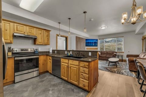 The well-laid-out kitchen boasts spacious countertops, stainless steel appliances, and a kitchen bar with four bar stools that connects the kitchen with the living room/dining area.