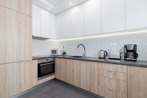 An alternate view of the kitchen highlighting ample countertop space, a small dining area, and modern finishes.