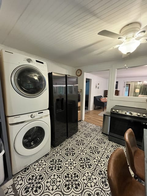Front load washer and dryer alongside the refrigerator.
