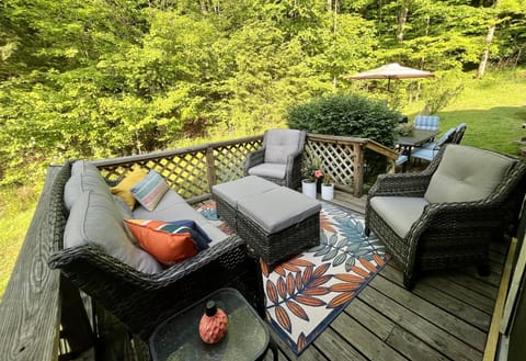 Sliding glass doors open up to the perfect seating area with a view of the woods
