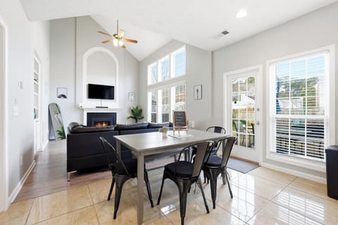 Sunny vaulted living-dining with fireplace, big windows & patio access
