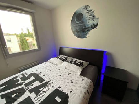 Gros plan sur la tête de lit avec déco Étoile de la Mort et bandeau LED bleu