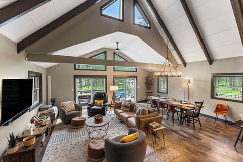 Open-concept living and dining area features vaulted ceilings, stylish décor, and plenty of natural light.