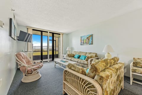 The living area offers pleanty of seating, a flat screen tv, and sliders to the ground floor pation just steps from the pool.