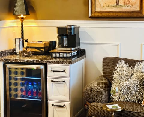 The beverage bar has bottled water, a Keurig, Illy coffee beans and a grinder.