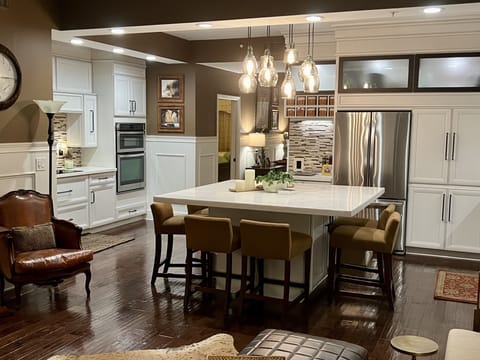 The updated kitchen seats 8 with an oversized dining bar of natural stone. 