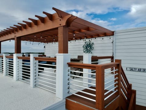 The rooftop has a large couch and chairs and a table for six.