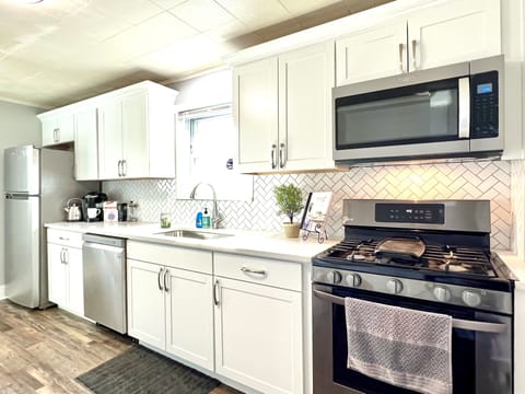 Newly updated kitchen with stainless appliances and white quartz countertops.