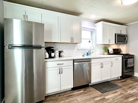 Newly updated kitchen with stainless appliances and white quartz countertops.