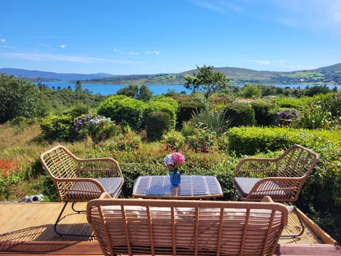 A large sunny deck with sea and mountain views 