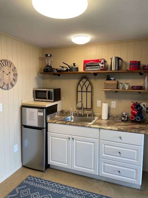 Kitchen complete with microwave, refrigerator, Keurig, garbage disposal, toaster oven, single burner hot plate, hot water kettle, blender, dishes, pots & pans & utensils. Sliding glass door in kitchen opens onto deck overlooking the lake.