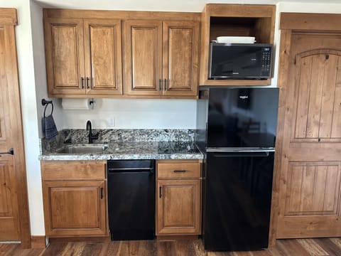 Kitchenette with dishwasher, stovetop, microwave.