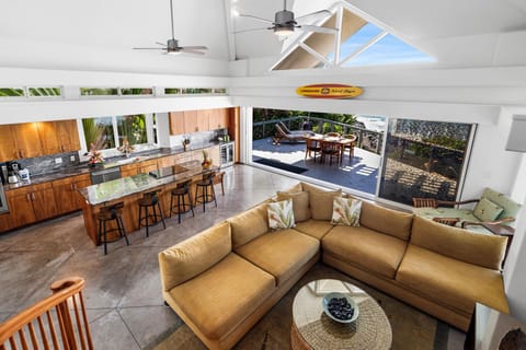 Indoor-outdoor flow connects the kitchen to lounge seating and dining on the covered lanai.