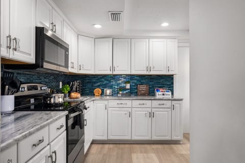 Second view of the fully equipped kitchen with custom tile backsplash.