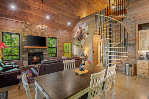 Cozy living room with fireplace, TV, and cabin charm.