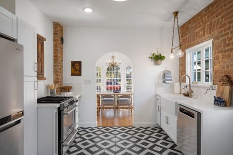 Modern kitchen with original hardware and exposed brick.  