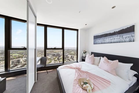 The master bedroom with a queen-sized bed, plush pillows.
