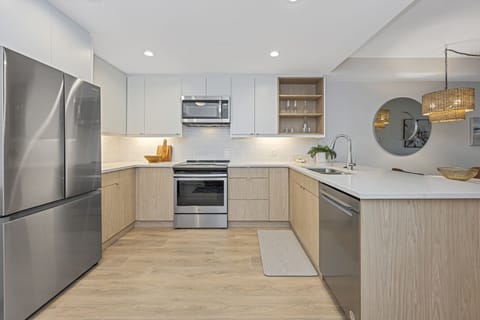 Fully equipped kitchen with quartz countertops and undercabinet lighting.