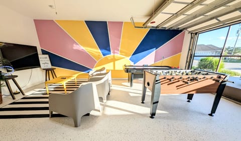 garage game room featuring foosball, air hockey, corn hole and retro video games