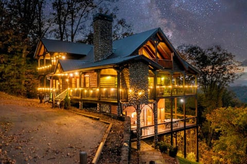 Magical mountain retreat glowing warmly under a starlit sky, your perfect scape.