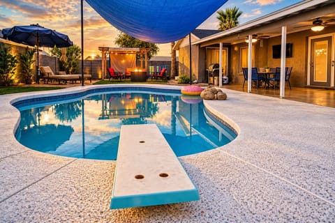 Resort-style backyard with pool, fire pit, grill & sunset ambiance