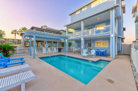 Charming coastal vacation home featuring a private pool and spacious outdoor entertaining area with tropical landscaping.