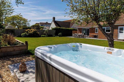 Escape to the south coast and unwind at this spacious home for 8 close to beaches, complete with manicured garden and hot tub (surcharge applies).