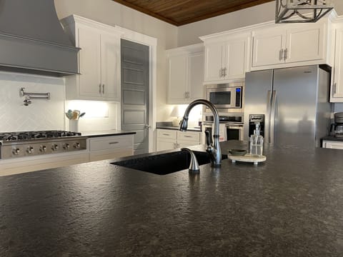 Kitchen with gas stove, pot filler, touch faucet.