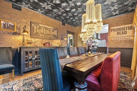 Step into a true speakeasy dining room featuring rich velvet seating, a grand wood table, and vintage Prohibition-era décor.