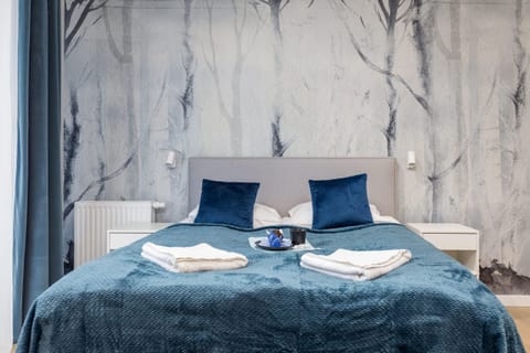 A stylish bedroom with a blue accent wall and modern bedding.
